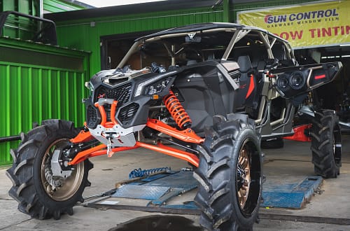 Can-Am Maverick X3 UTV that has a lift kit installed with aftermarket wheels and tires.